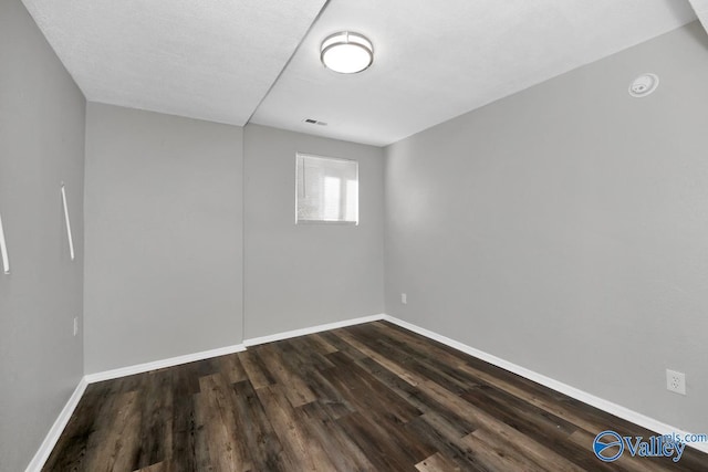 unfurnished room featuring dark hardwood / wood-style floors and a textured ceiling