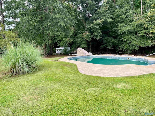 view of pool featuring a water slide and a yard