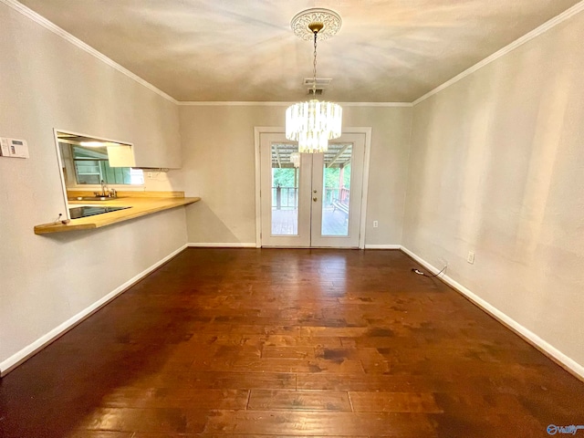 unfurnished dining area featuring ornamental molding, dark hardwood / wood-style floors, sink, and a chandelier