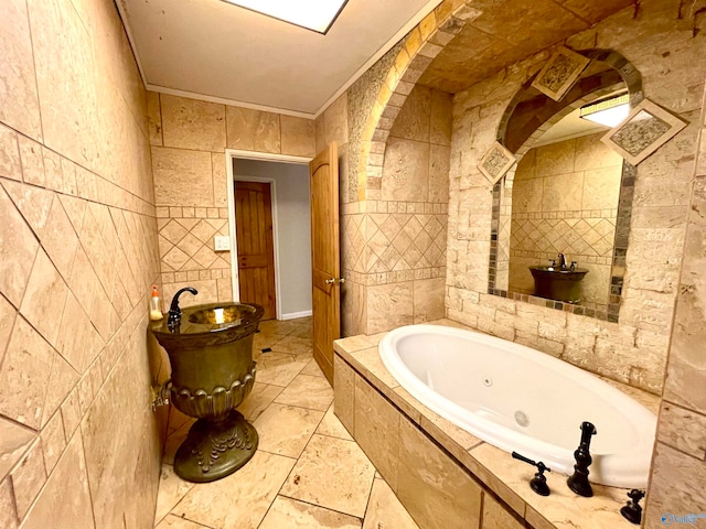 bathroom with tile walls, tiled tub, and ornamental molding