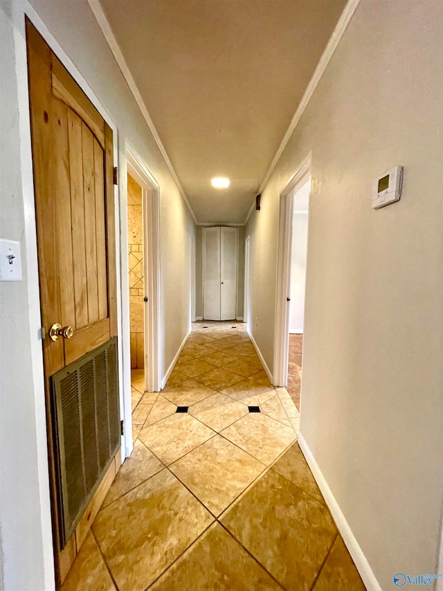 hall featuring ornamental molding and light tile patterned floors