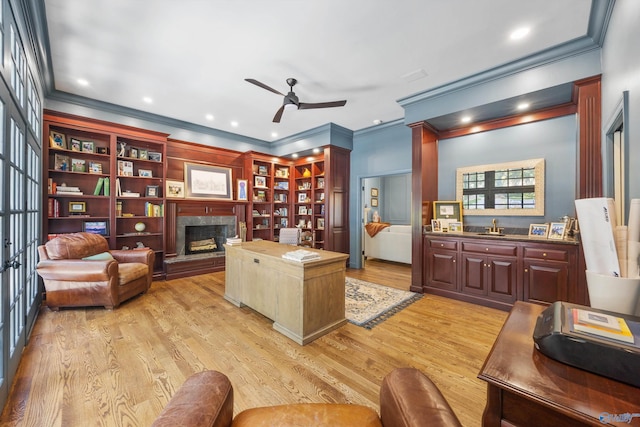 office area with a tile fireplace, ornamental molding, sink, and light hardwood / wood-style floors