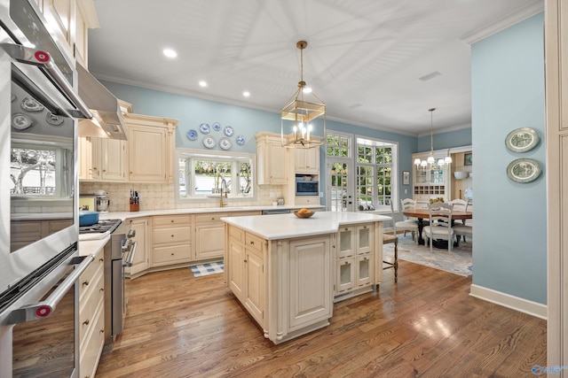 kitchen featuring a breakfast bar, a center island, a notable chandelier, pendant lighting, and backsplash