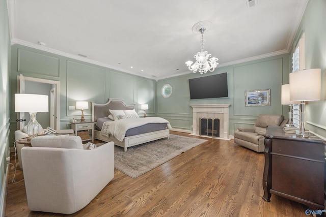 bedroom featuring hardwood / wood-style flooring, crown molding, an inviting chandelier, and multiple windows