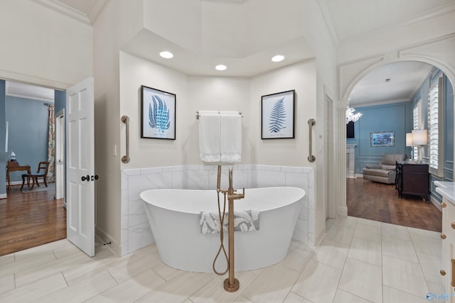 bathroom featuring tile patterned flooring, a bathing tub, and crown molding