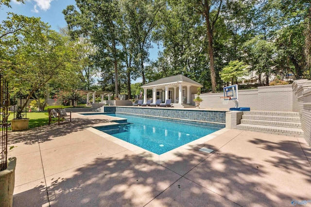 view of swimming pool featuring an outbuilding and a patio area