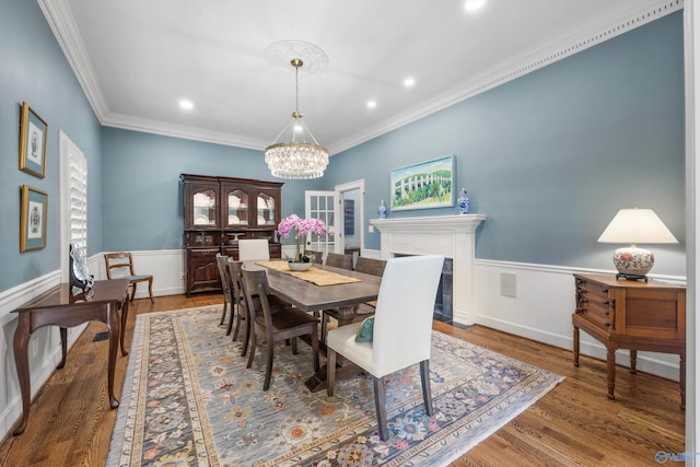 dining room with crown molding, dark wood-type flooring, and an inviting chandelier