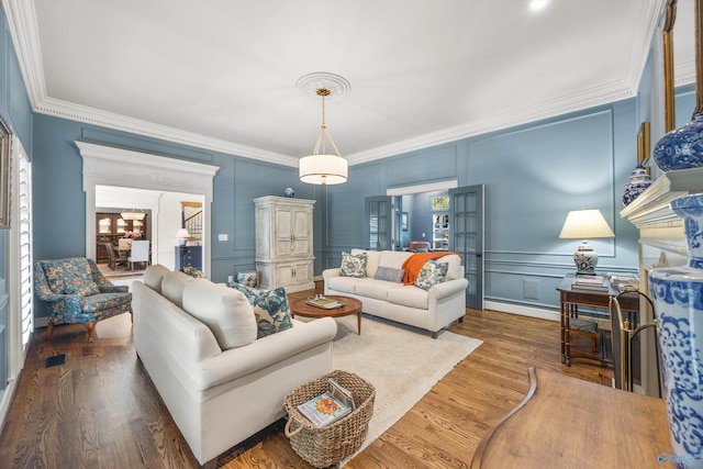 living room with ornamental molding and wood-type flooring