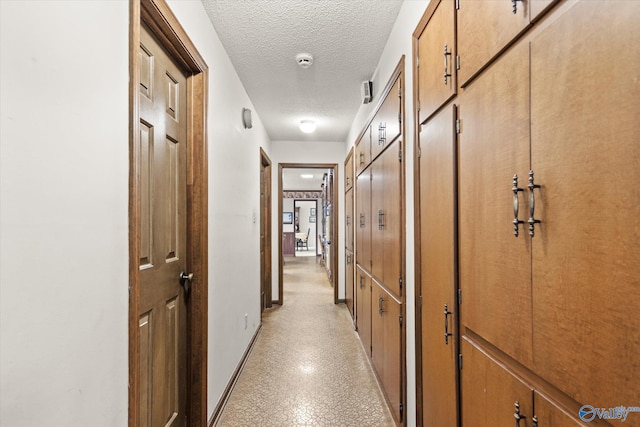 hall with a textured ceiling