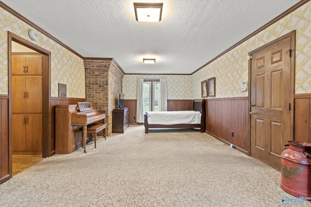 bedroom with wood walls, a textured ceiling, light colored carpet, and crown molding