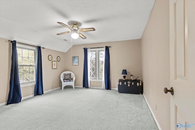 sitting room featuring vaulted ceiling, light carpet, ceiling fan, and a textured ceiling