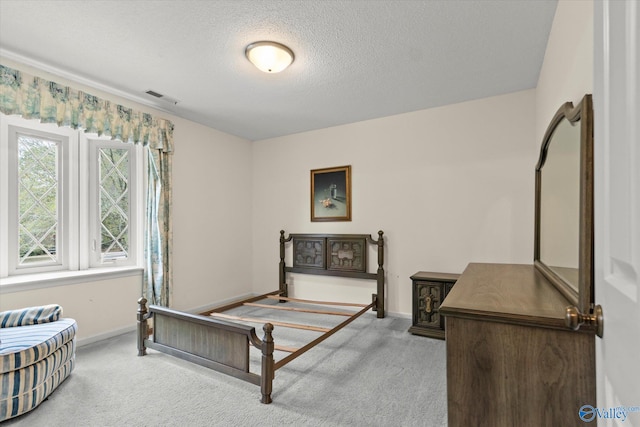 bedroom with a textured ceiling and light carpet