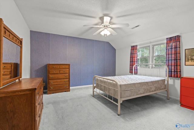 carpeted bedroom featuring a textured ceiling, vaulted ceiling, and ceiling fan