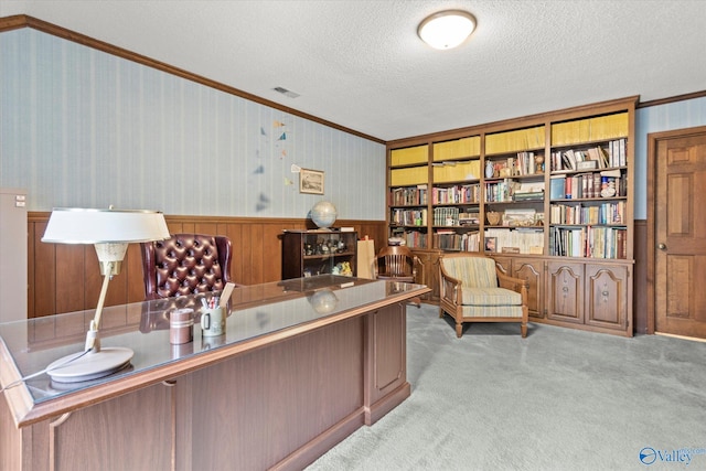 carpeted home office with a textured ceiling and crown molding