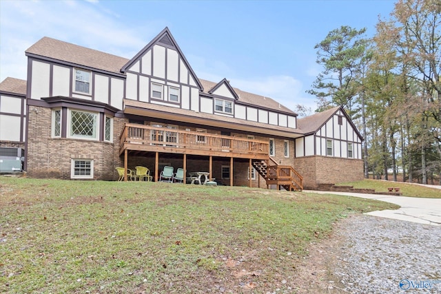 back of house featuring a lawn and a wooden deck