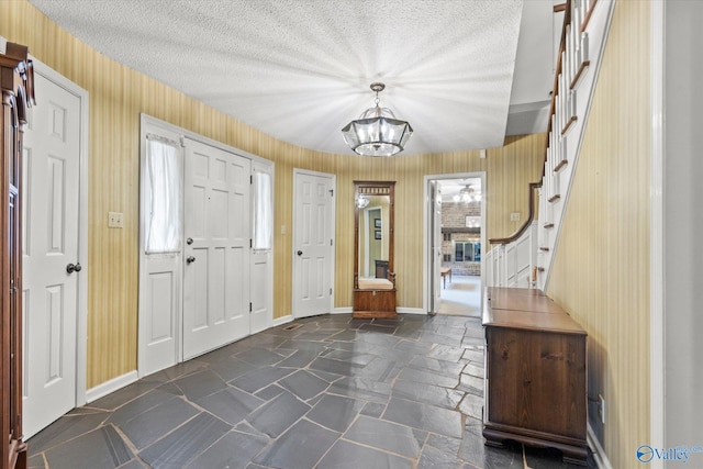 entrance foyer with an inviting chandelier, a healthy amount of sunlight, and a textured ceiling