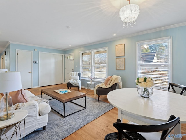 living room featuring light hardwood / wood-style floors, crown molding, and a notable chandelier