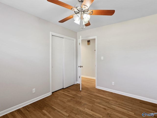 unfurnished bedroom featuring ceiling fan, a closet, and hardwood / wood-style floors