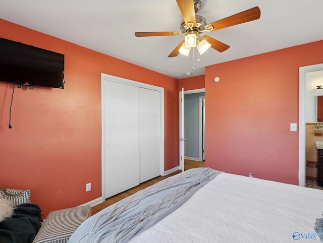 bedroom with ceiling fan, hardwood / wood-style floors, ensuite bathroom, and a closet