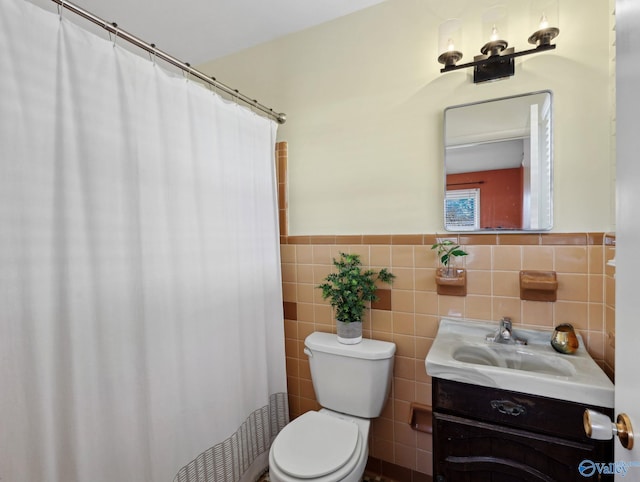 bathroom featuring tile walls, toilet, and vanity