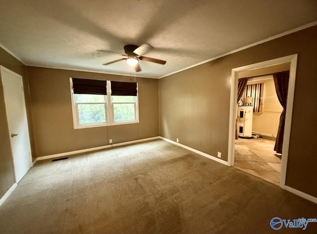 unfurnished bedroom featuring water heater, crown molding, baseboards, and carpet floors