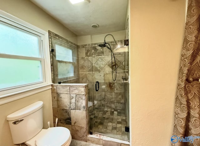 full bath featuring a stall shower and toilet
