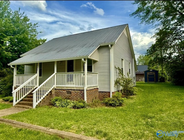 view of front of home with an outdoor structure, metal roof, a shed, a porch, and a front lawn