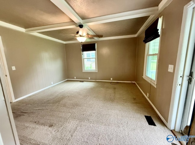 empty room with visible vents, coffered ceiling, carpet floors, baseboards, and a ceiling fan