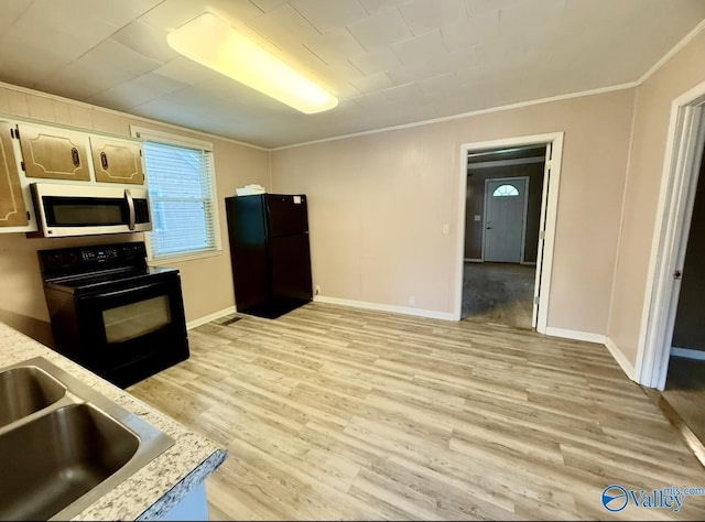kitchen featuring light countertops, black appliances, light wood-style flooring, baseboards, and ornamental molding
