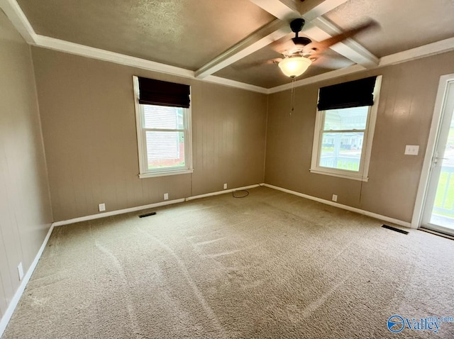 carpeted empty room with ornamental molding, ceiling fan, beam ceiling, and baseboards