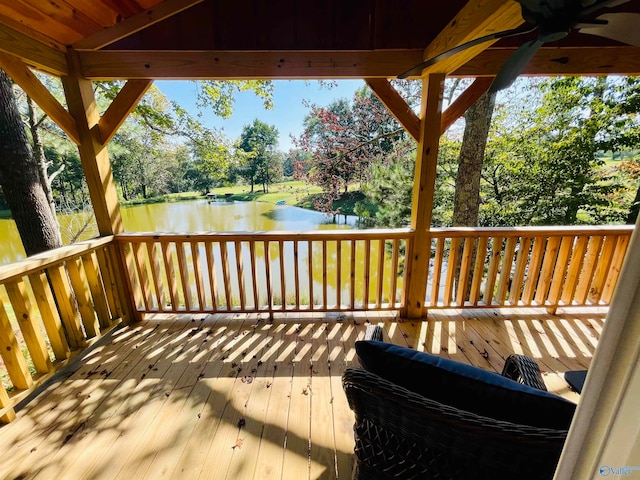 wooden deck featuring a water view and ceiling fan