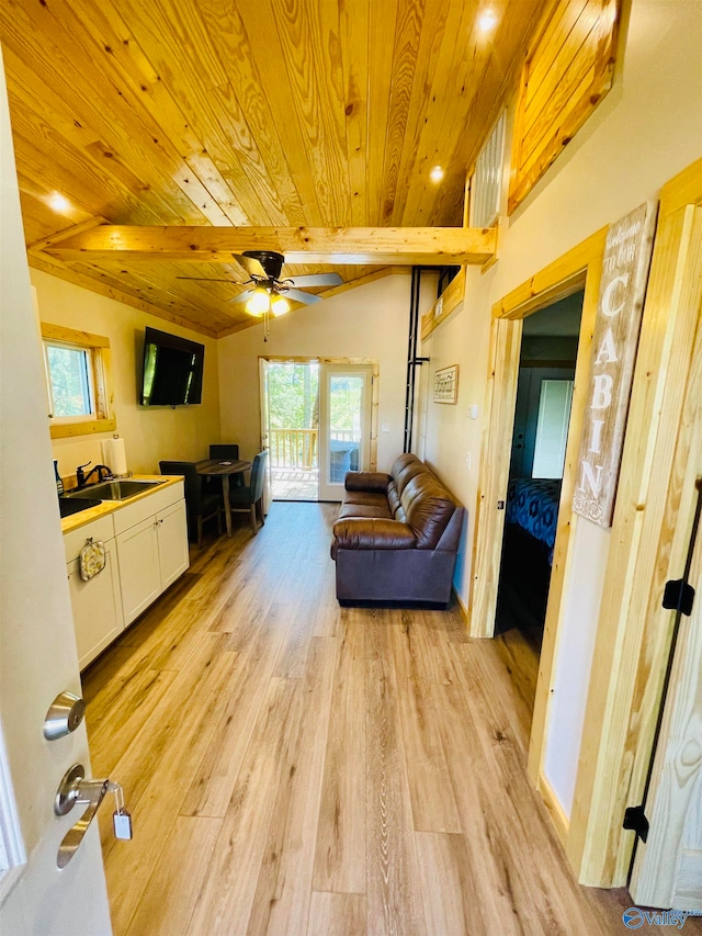 living room featuring lofted ceiling with beams, wooden ceiling, light wood-type flooring, and ceiling fan