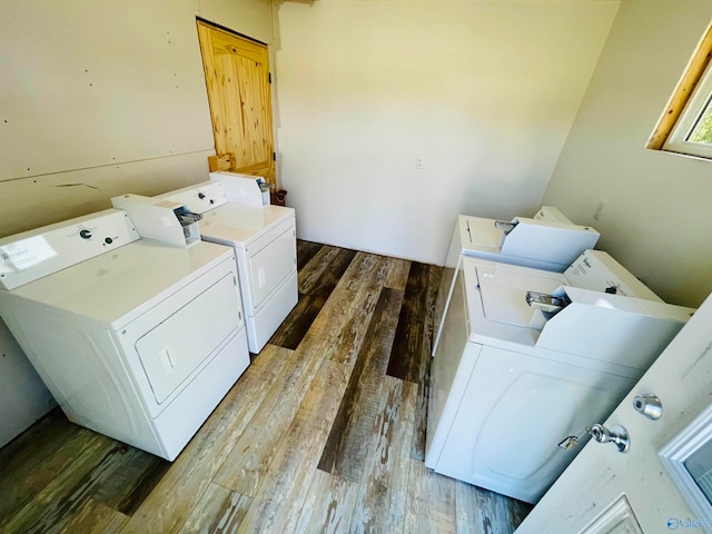 laundry area featuring wood-type flooring and separate washer and dryer