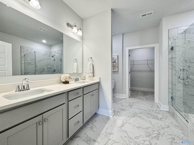 bathroom with a marble finish shower, visible vents, marble finish floor, and a sink