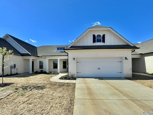 view of front of house featuring a shingled roof, concrete driveway, a garage, board and batten siding, and brick siding