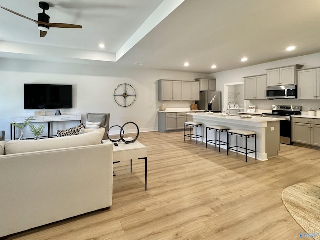 living area featuring recessed lighting, baseboards, light wood-style flooring, and a ceiling fan