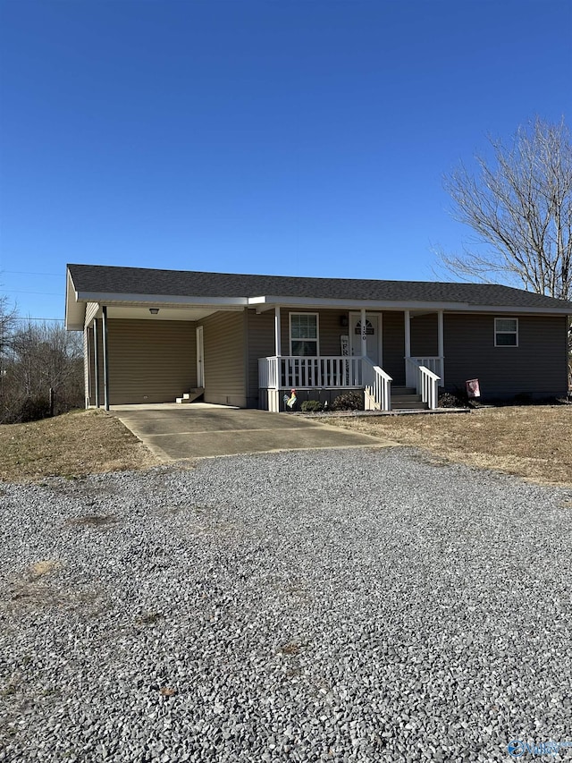 ranch-style home featuring covered porch and a carport