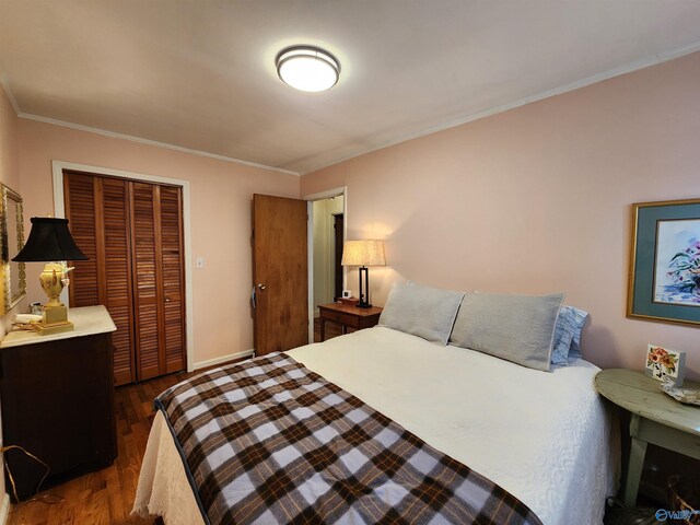 bedroom with dark hardwood / wood-style flooring, crown molding, and a closet