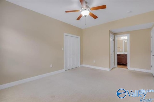 unfurnished bedroom with light carpet, ceiling fan, and ensuite bathroom