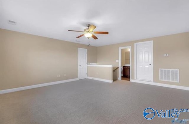 carpeted spare room featuring ceiling fan