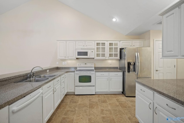 kitchen featuring lofted ceiling, white appliances, a sink, white cabinetry, and glass insert cabinets