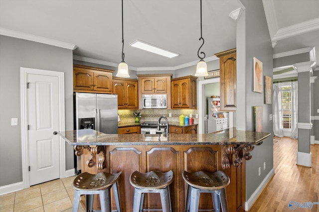 22915 Pin Oak Dr, Athens, AL 35613 - kitchen with appliances with stainless steel finishes, brown cabinets, ornamental molding, and tasteful backsplash
