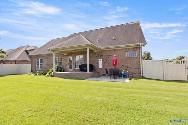 22915 Pin Oak Dr, Athens, AL 35613 - back of property featuring a fenced backyard, a patio, brick siding, and a lawn
