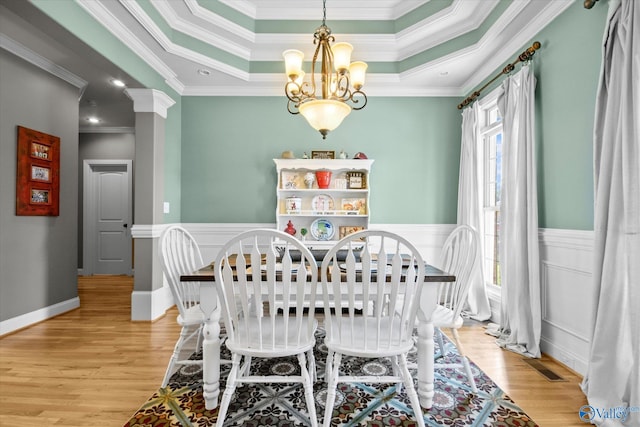 22915 Pin Oak Dr, Athens, AL 35613 - dining room with a wainscoted wall, a notable chandelier, a raised ceiling, visible vents, and light wood-type flooring
