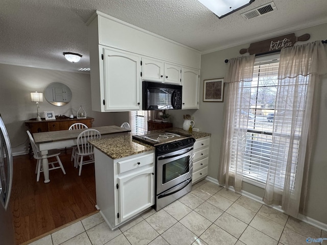 kitchen with stainless steel range with electric stovetop, dark stone countertops, white cabinets, plenty of natural light, and light tile patterned flooring