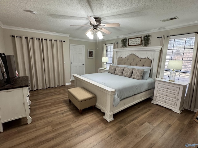 bedroom with ceiling fan, crown molding, dark hardwood / wood-style flooring, and a textured ceiling