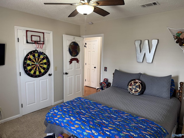 carpeted bedroom featuring a textured ceiling and ceiling fan