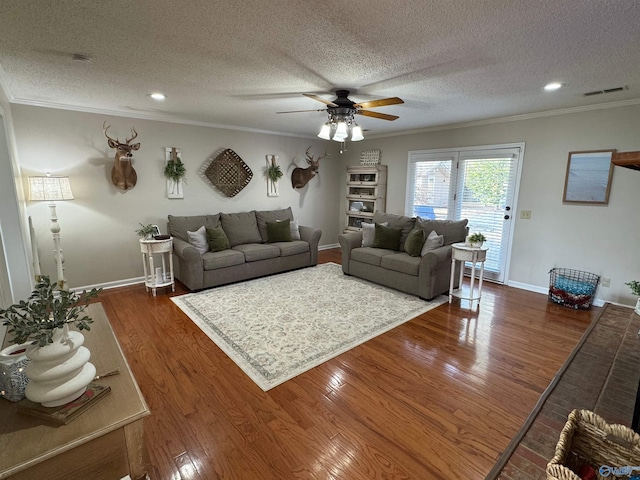 living room featuring ceiling fan, a textured ceiling, dark hardwood / wood-style floors, and crown molding