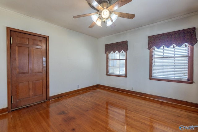 unfurnished room with hardwood / wood-style floors, crown molding, and baseboards