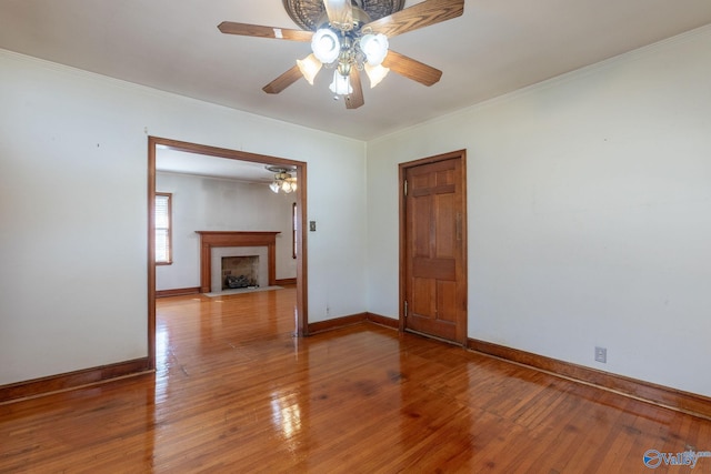 unfurnished room with baseboards, light wood-style floors, and crown molding